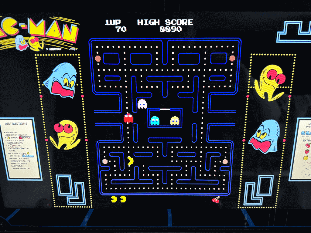 A close up of an arcade playing the Pacman arcade game.