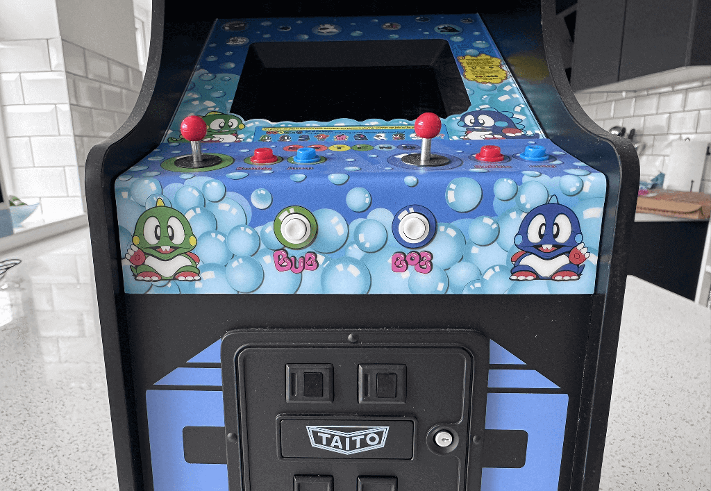 A Bubble Bobble quarter arcade cabinet on a quartz worktop surface in a kitchen.