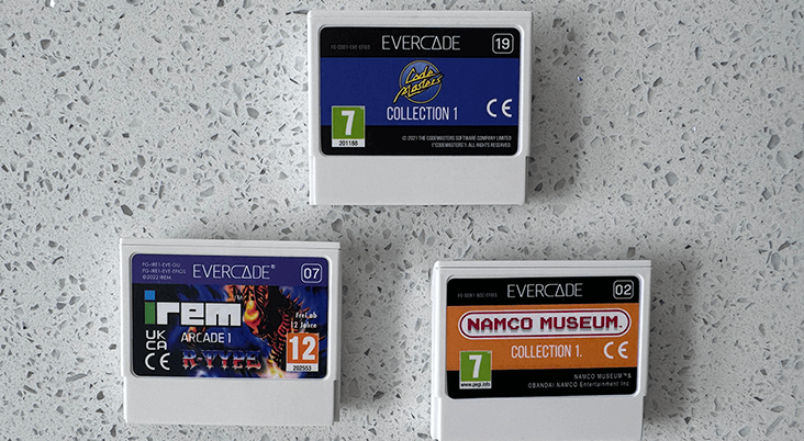 Three Evercade video game cartridges on a gray speckled surface.