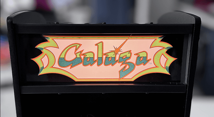 A Galaga Quarter Arcade close up showing a lit Marquee and game playing.