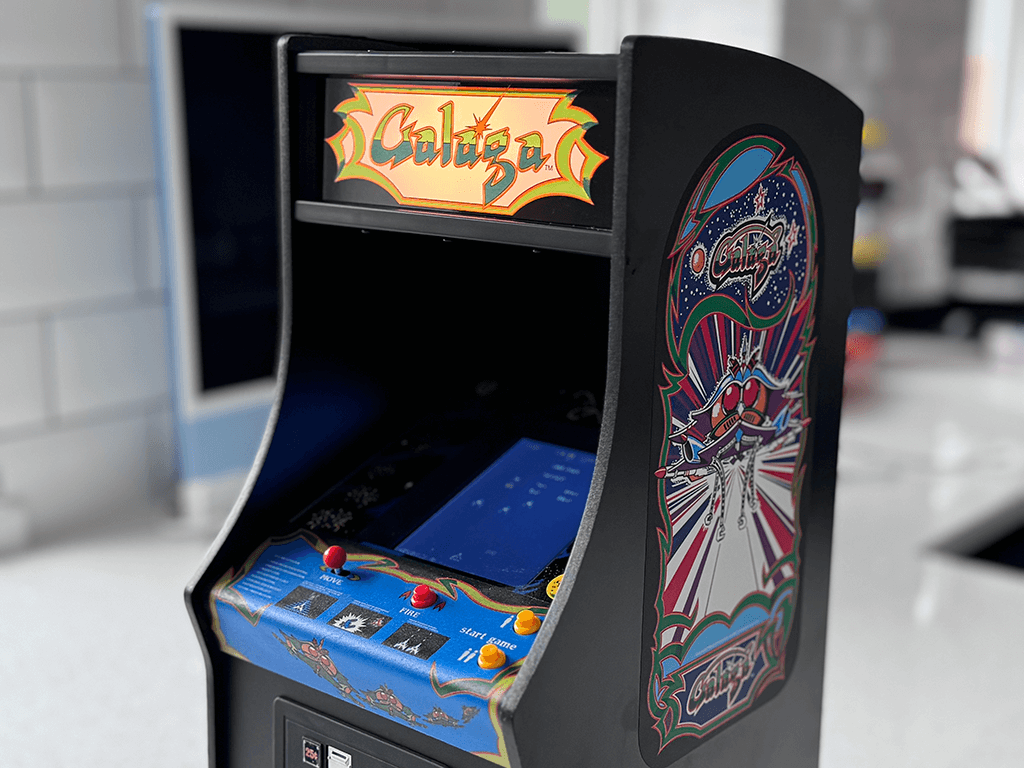 A Galaga Quarter Arcade angled view showing the orginal cabinet art and lit marquee.