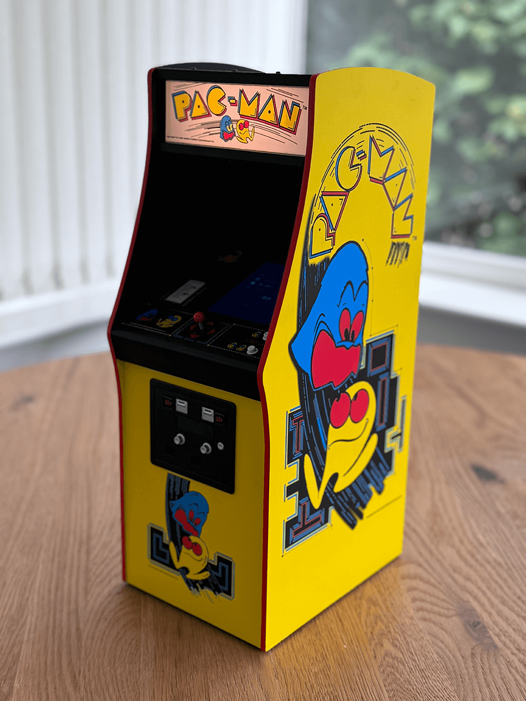 A PAC-MAN Quarter Arcade angled view showing the orginal cabinet art and lit marquee.