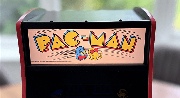 A PAC-MAN Quarter Arcade close up showing a lit Marquee and game playing.