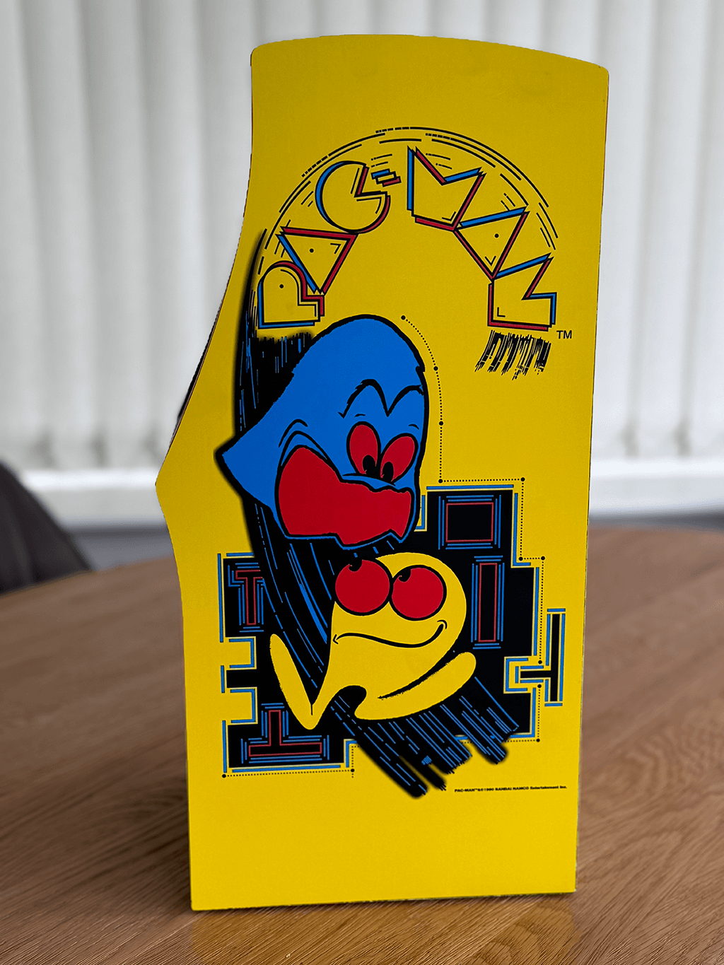 A PAC-MAN Quarter Arcade side view showing a the orginal cabinet art.