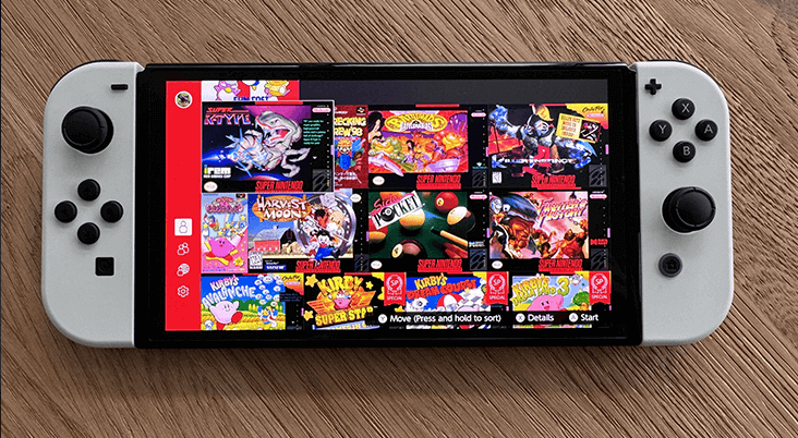 A Nitendo OLED Switch on a wooden surface displaying a selction of games from Nintendo Switch Online.